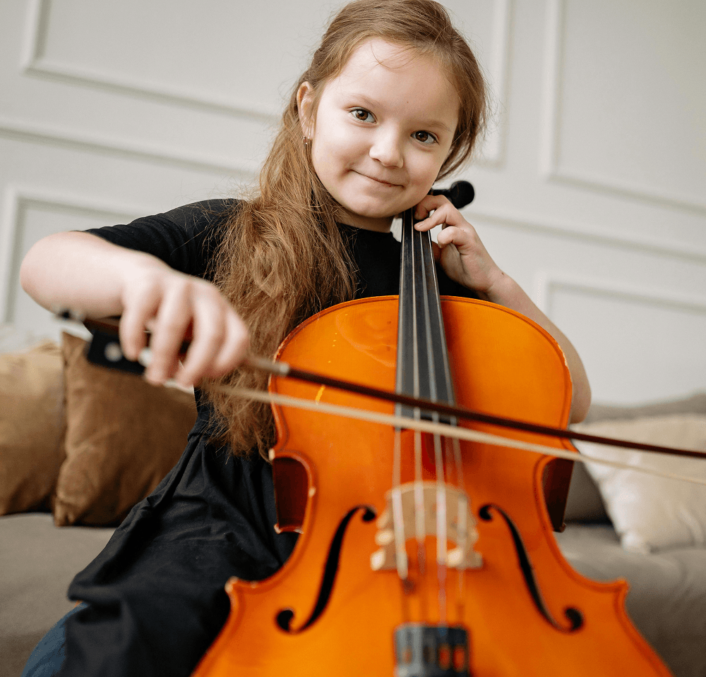 young girl smiling playing a string instrument